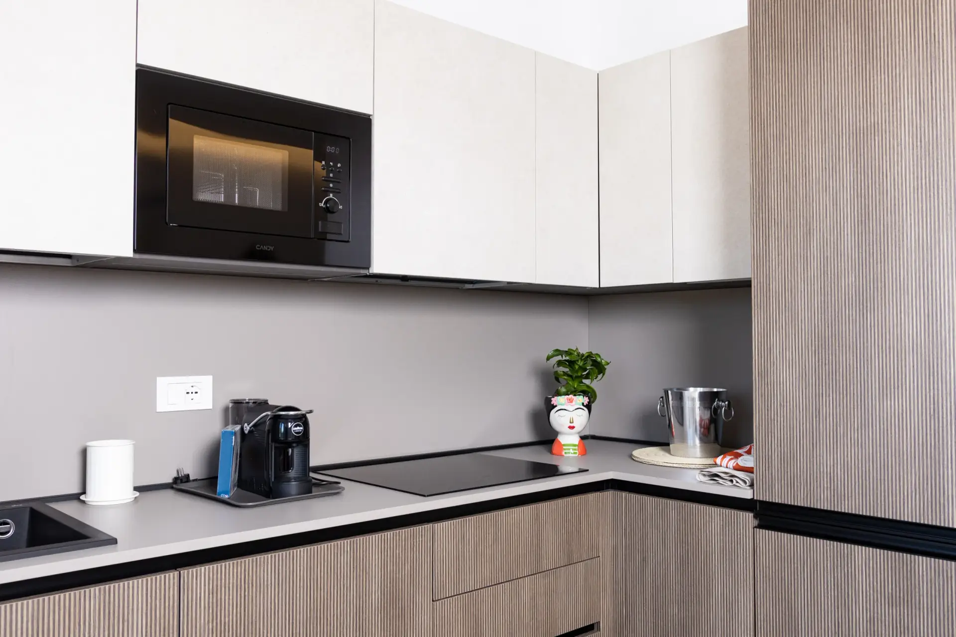 Angolo cottura con forno a microonde, macchina del caffè e piano a induzione