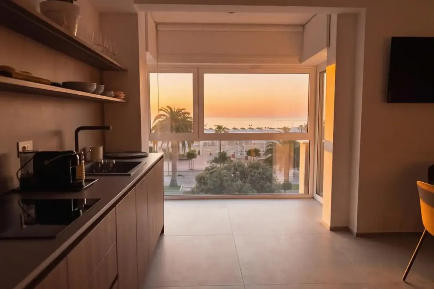 Alba vista dall interno dell appartamento, cucina e grande vetrata sul mare
