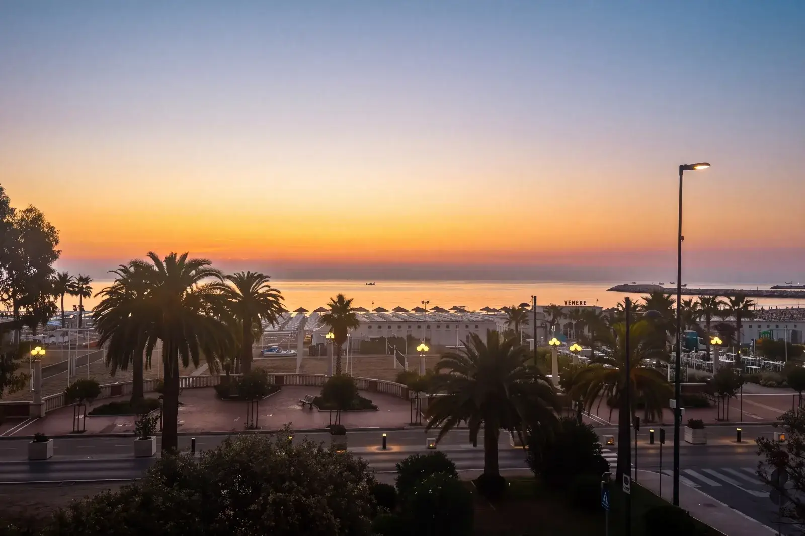 Alba sul lungomare di Giulianova con palme e stabilimenti balneari